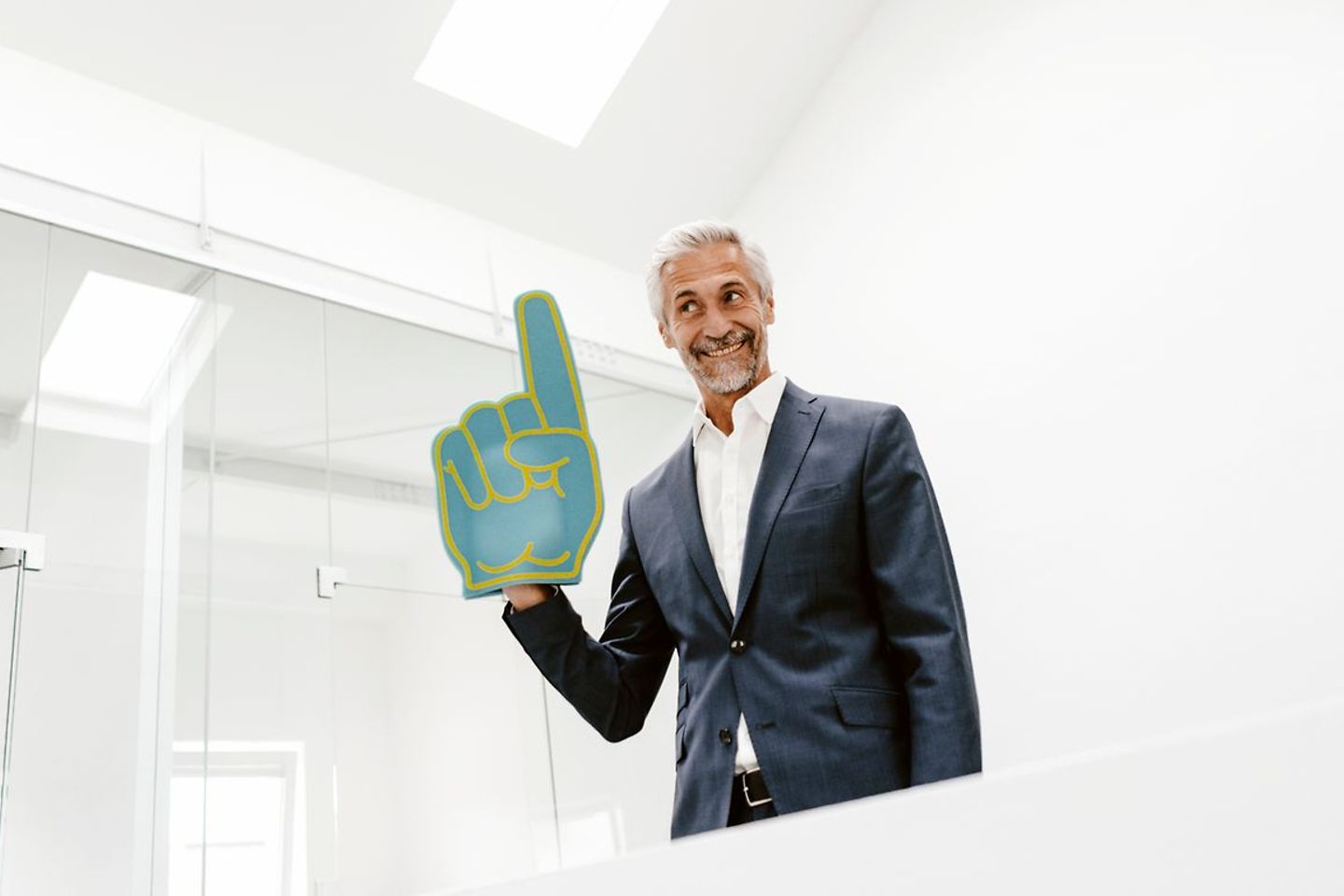 Smiling businessman holding toy hand