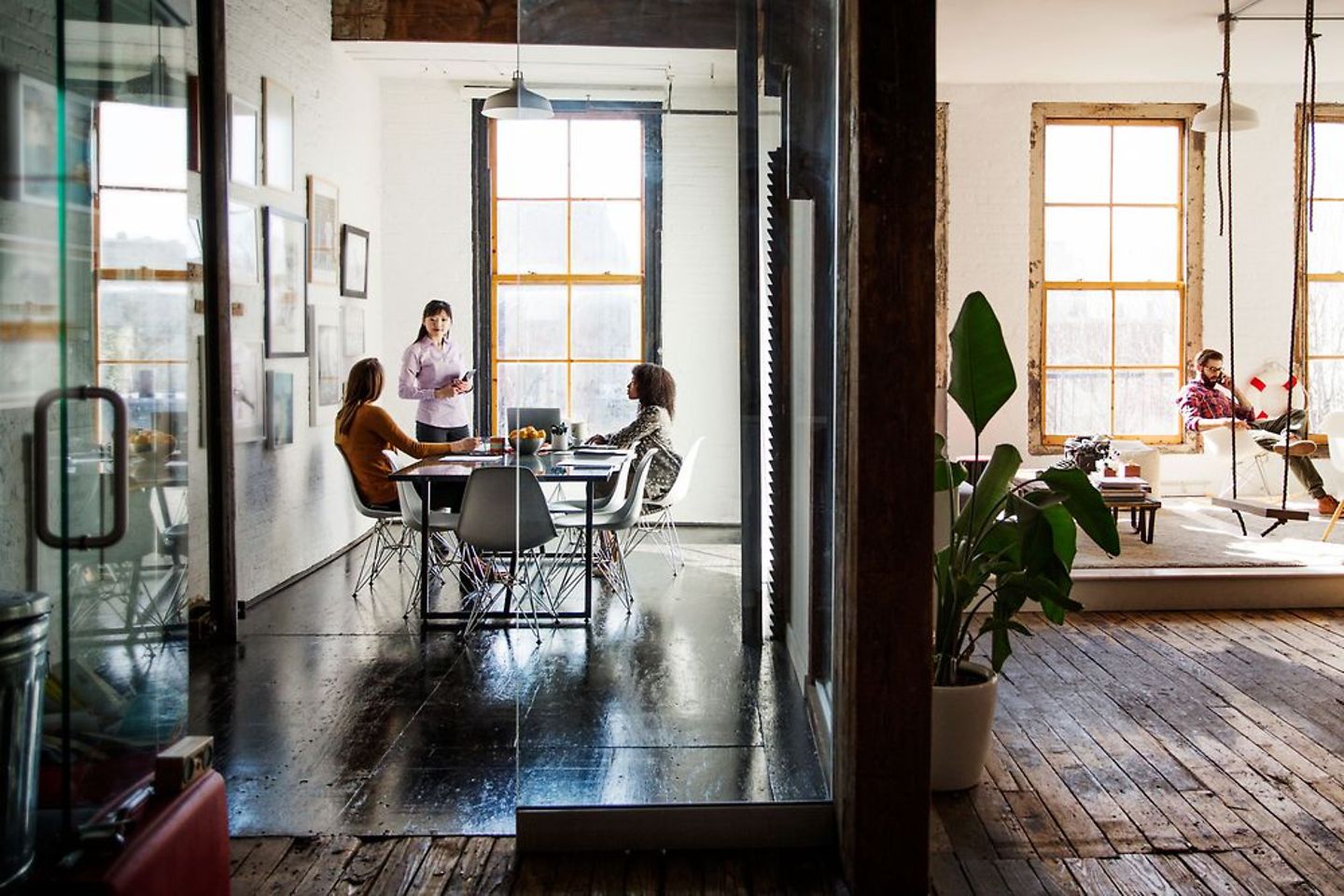 Fancy office in warm tones with wooden floors and some office workers in it