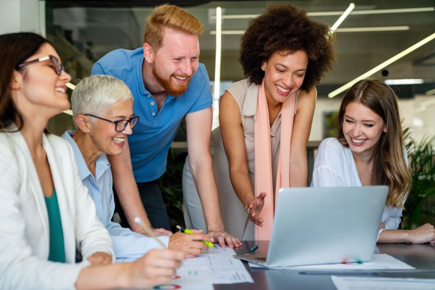 Gruppe von Beamten im Büro vor einem Rechner