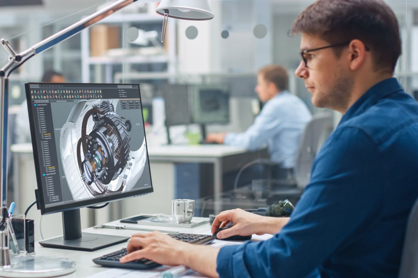 Blick über die Schulter eines Ingenieurs, der mit CAD-Software auf einem Desktop-Computer arbeitet