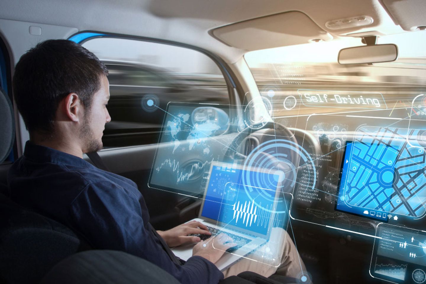 One man working on a laptop in a driverless car