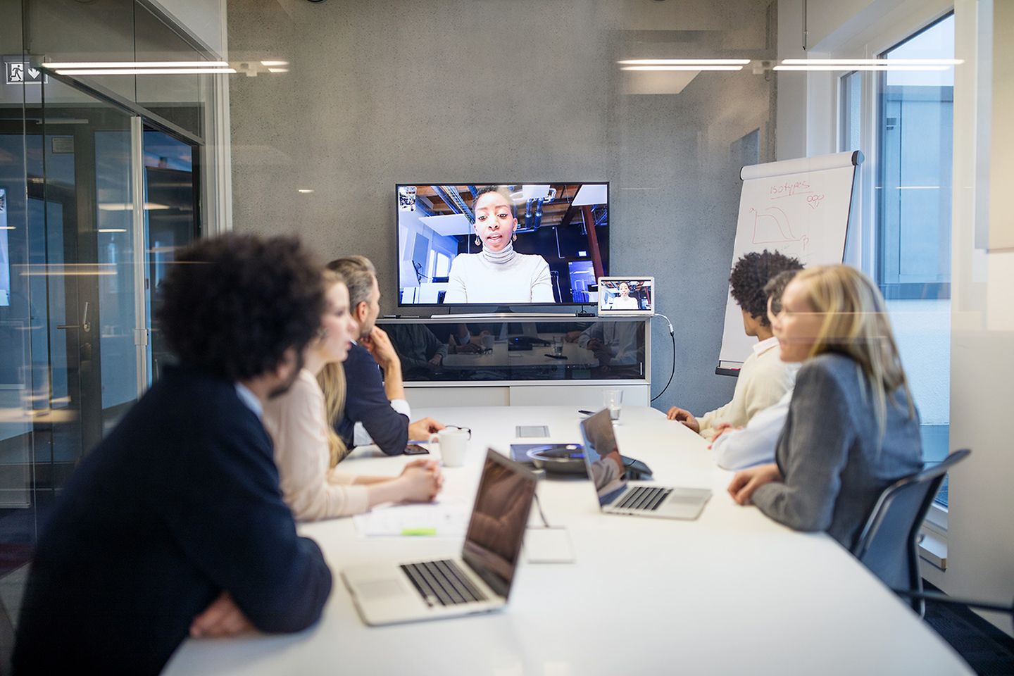 Office workers in an online meeting with a female colleague