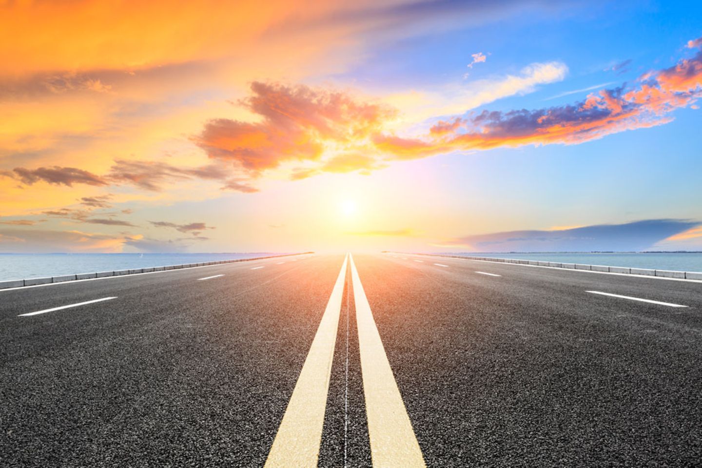 Empty asphalt highway at sunset