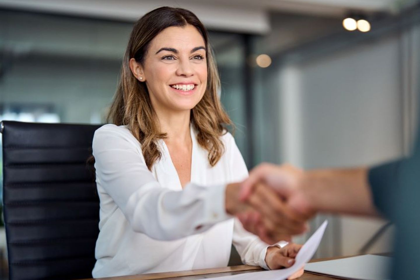 Administrative officer celebrating success in office with handshake