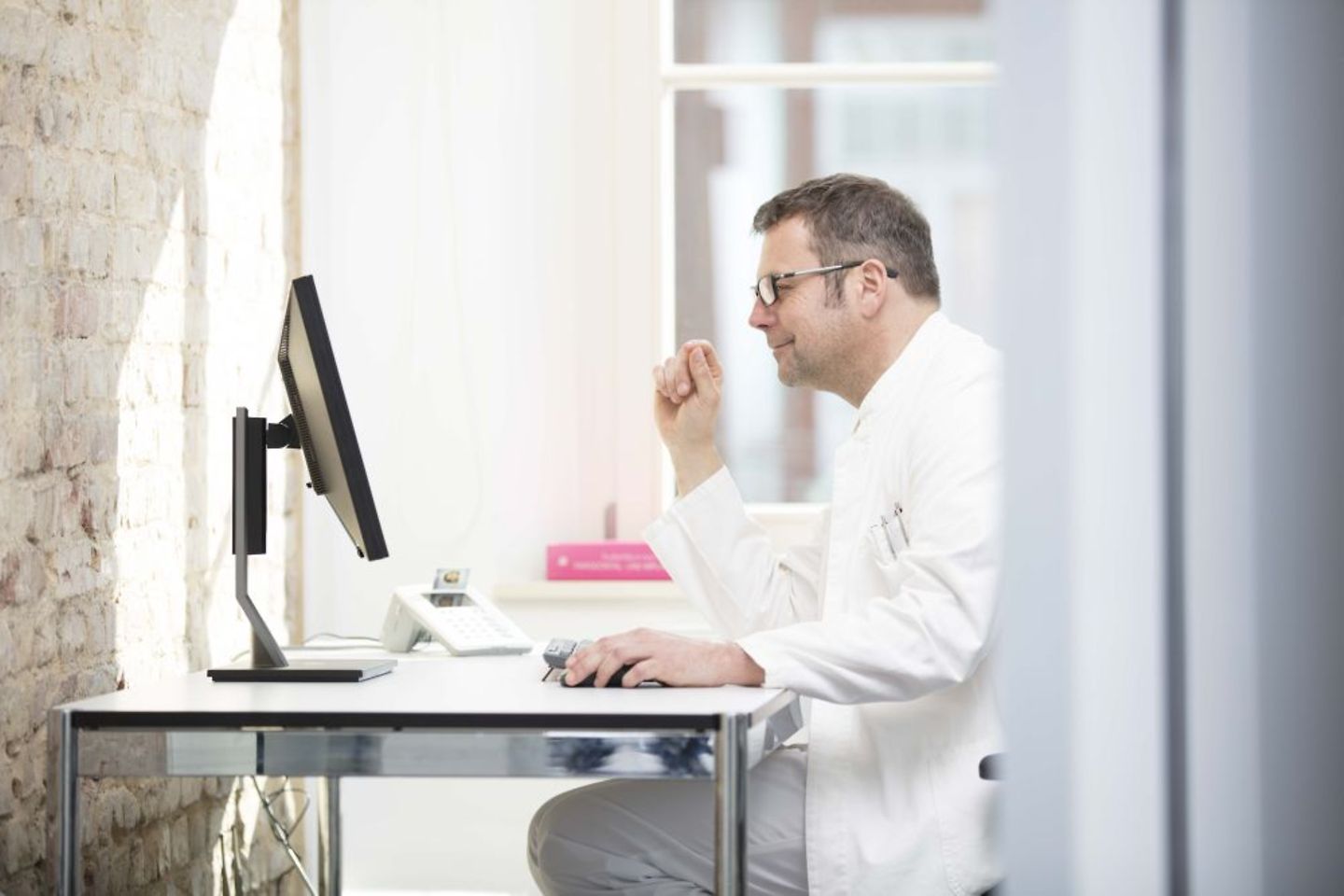 Doctor in a healthcare institution identifies himself on a computer using his SMC-B card in the Telematics Infrastructure