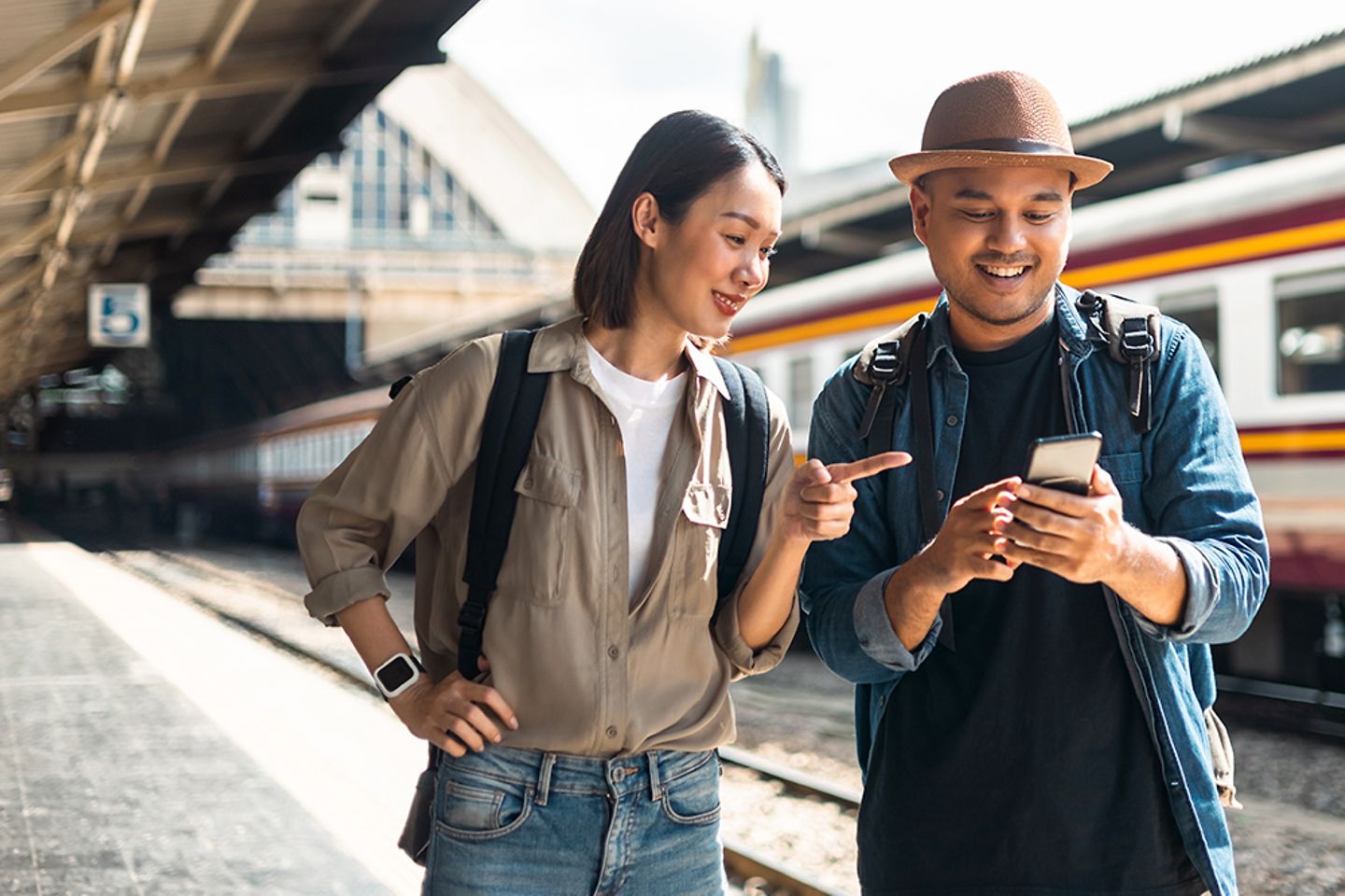 Two passengers looking at their phones for railway information