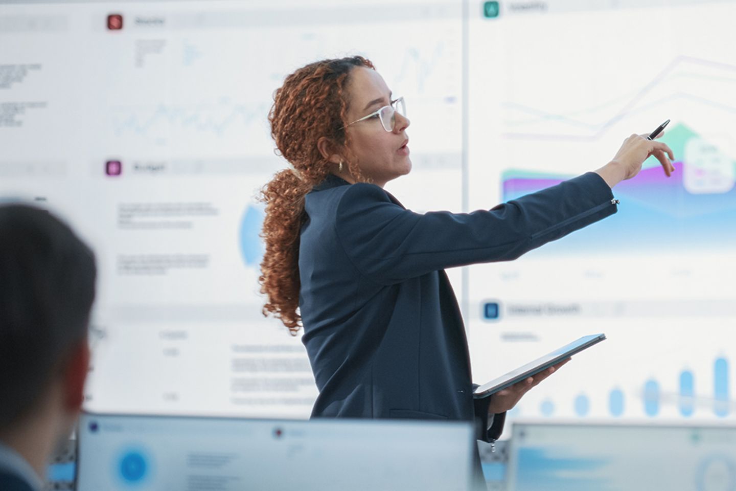 Data scientist checking key financial figures in front of a large digital screen