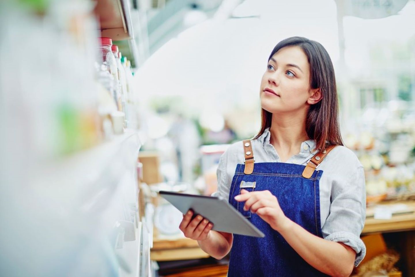 Une jeune employée effectue une saisie avec une tablette digitale dans le magasin