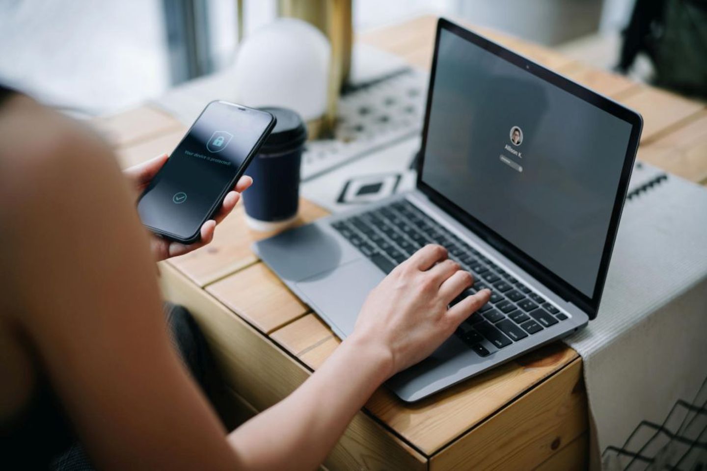 Gebruiker stelt beveiligingsinstellingen in op laptop met mobiele telefoon