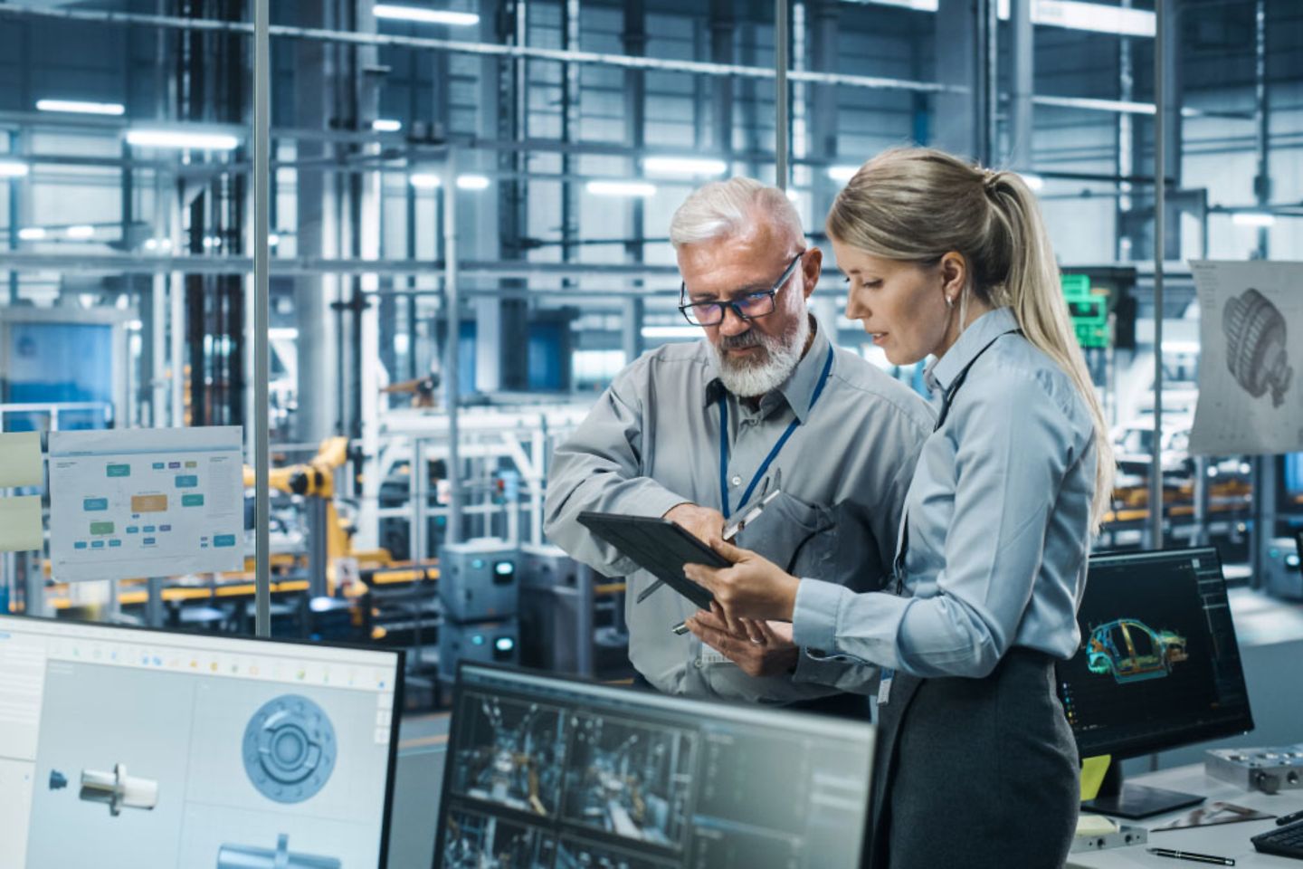 Colleagues in discussion on a tablet in an office in the automotive sector