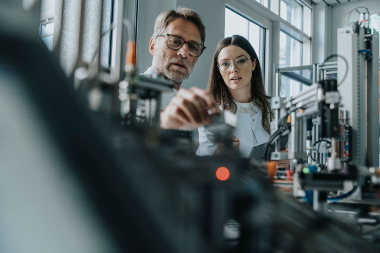 Man checks machine with his female colleague