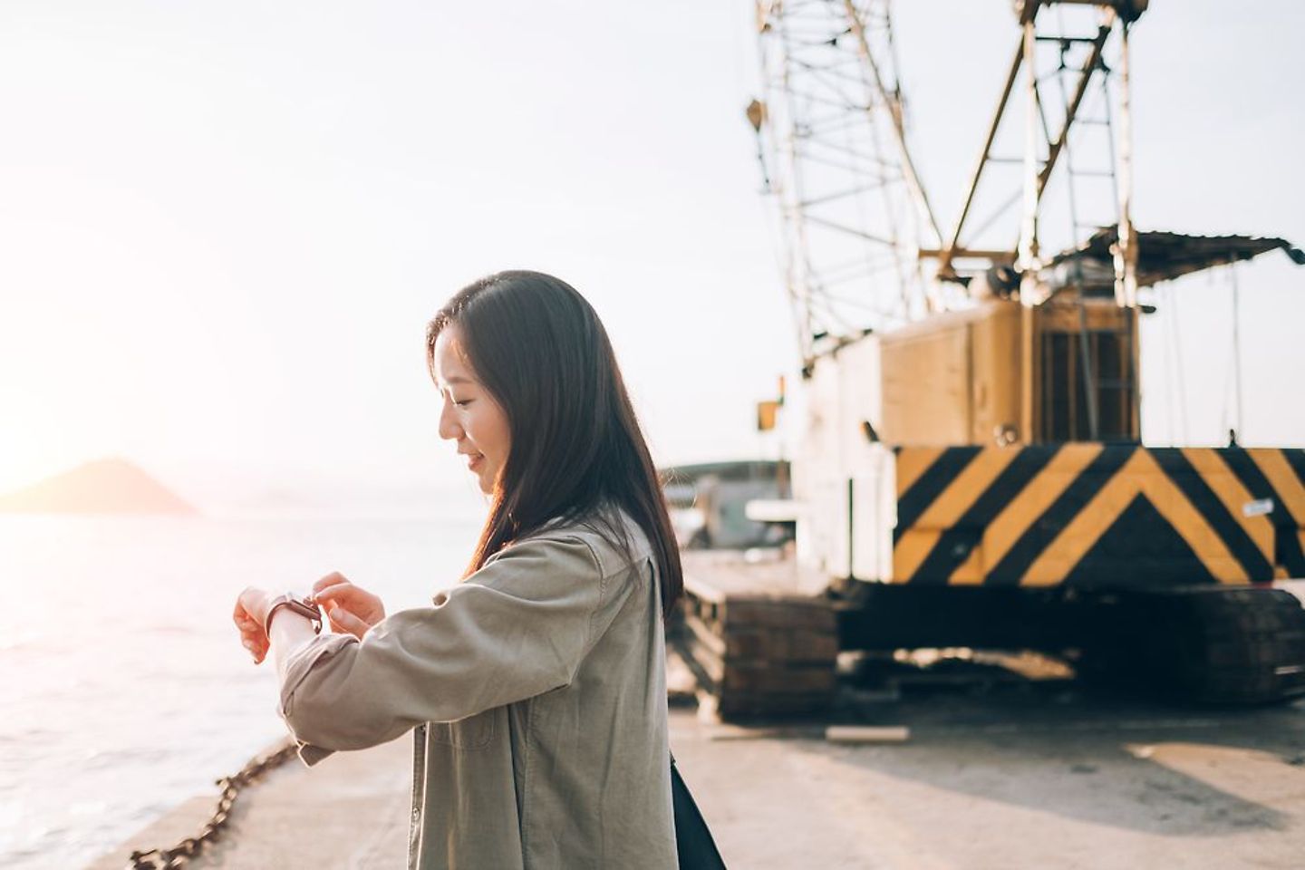 Woman looking at her smartwatch in an industrial port