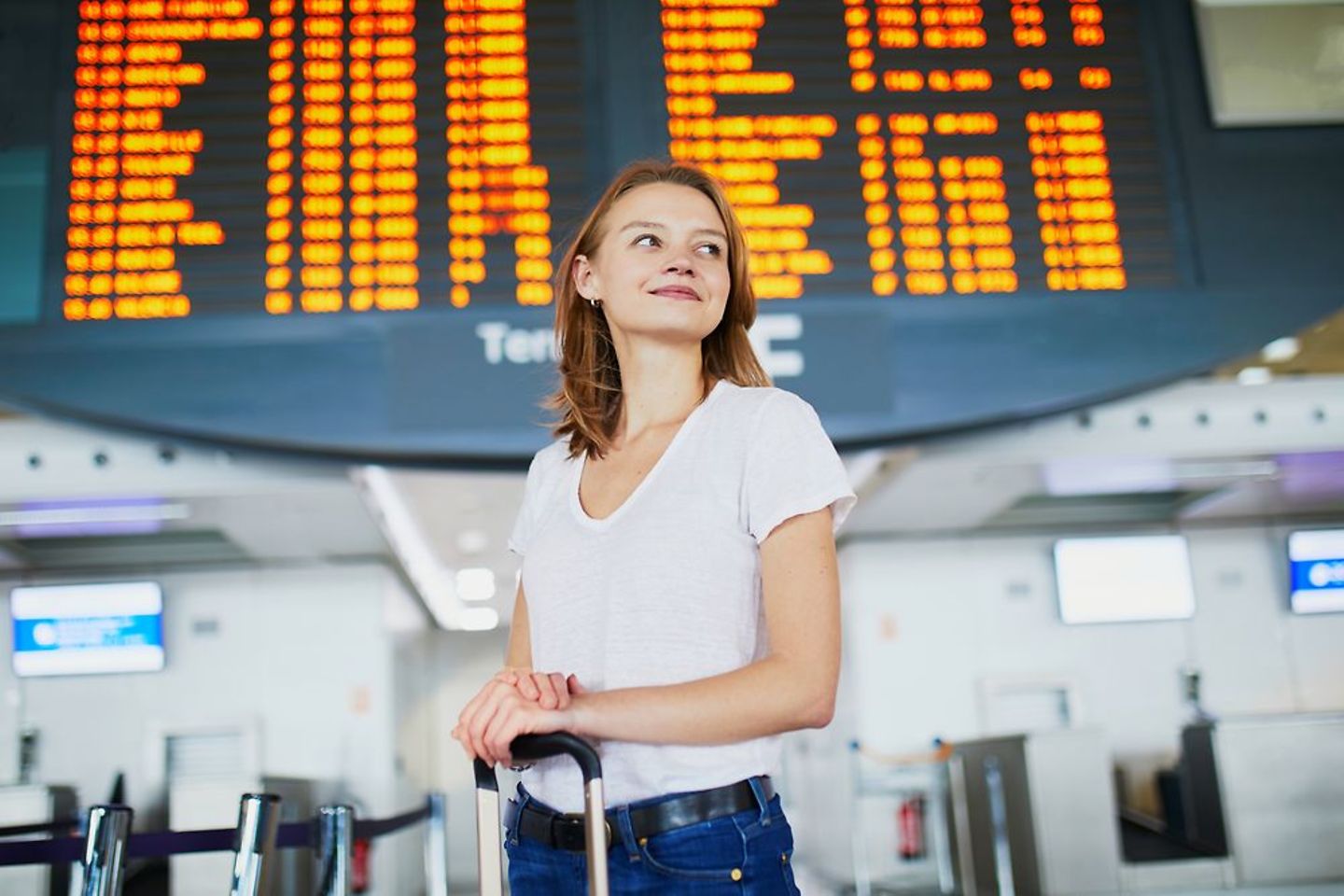 Frau wartet am Flughafen Schiphol auf ihren Flug