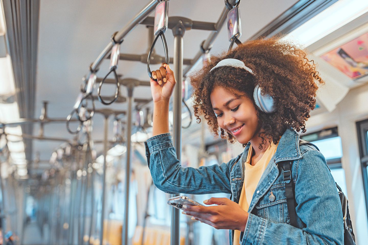 Pasajera con cara de felicidad escuchando música en su smartphone mientras viaja en tren
