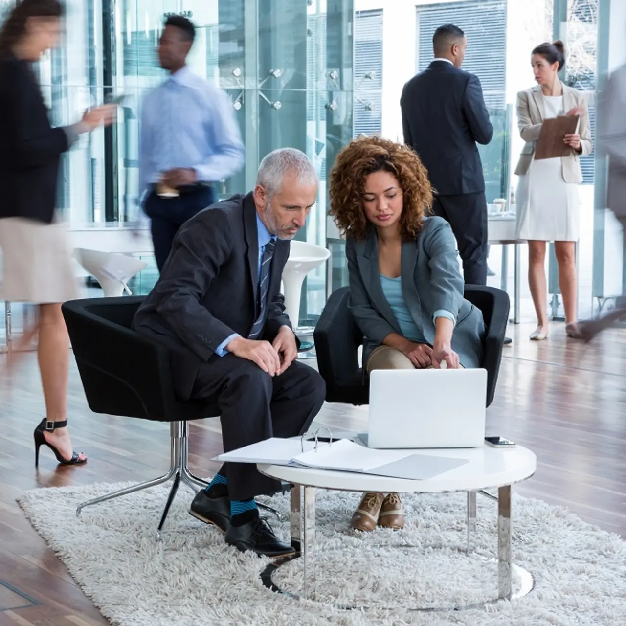 Zakenmensen bespreken gegevenstransformatie aan een tafel met een laptop erop