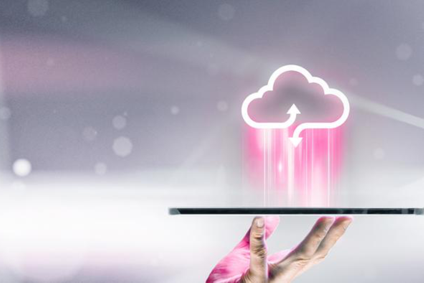 Eine menschliche Hand hält ein Tablet waagerecht nach oben, darüber ein Cloud-Symbol