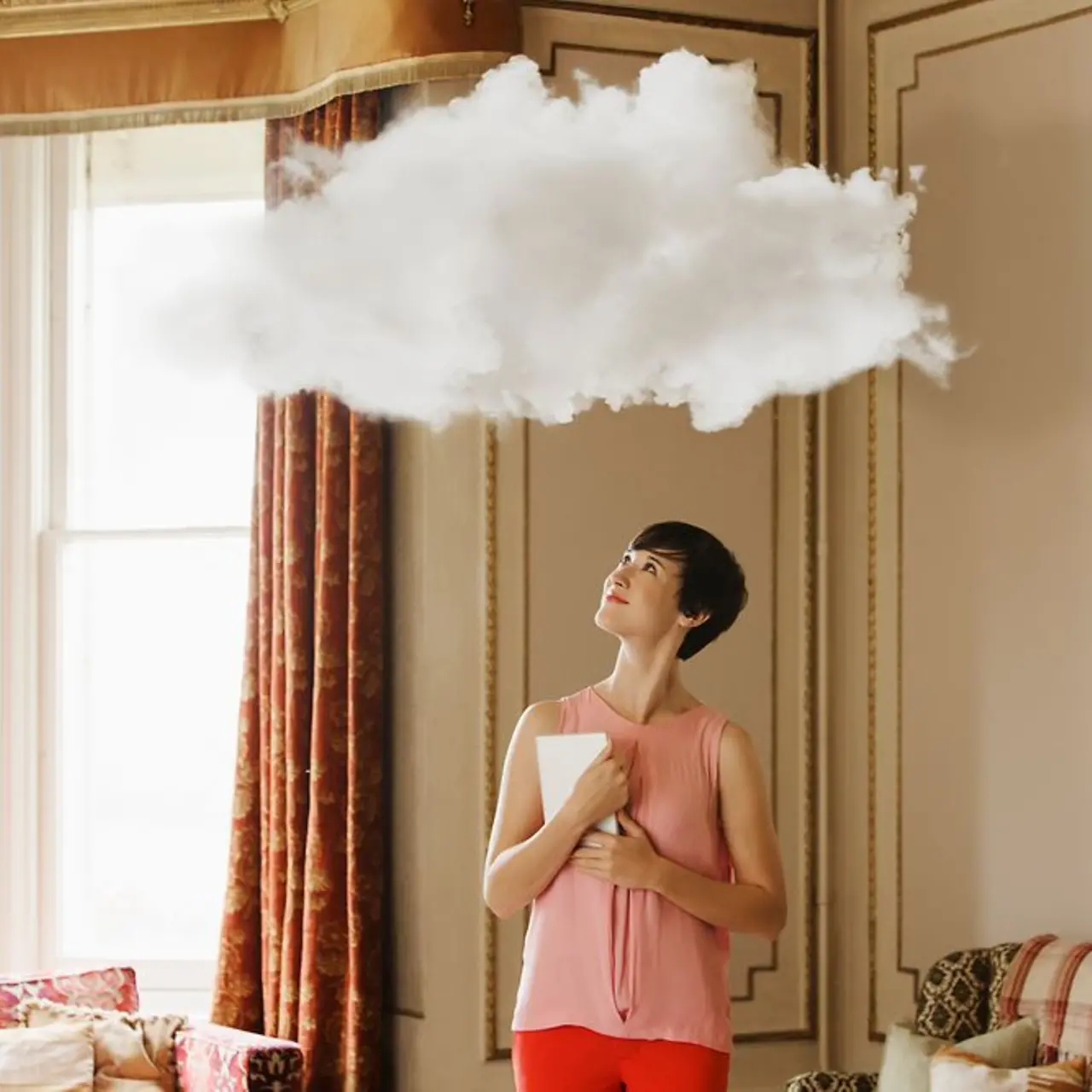 Frau mit Laptop schaut auf Wolke über ihrem Kopf