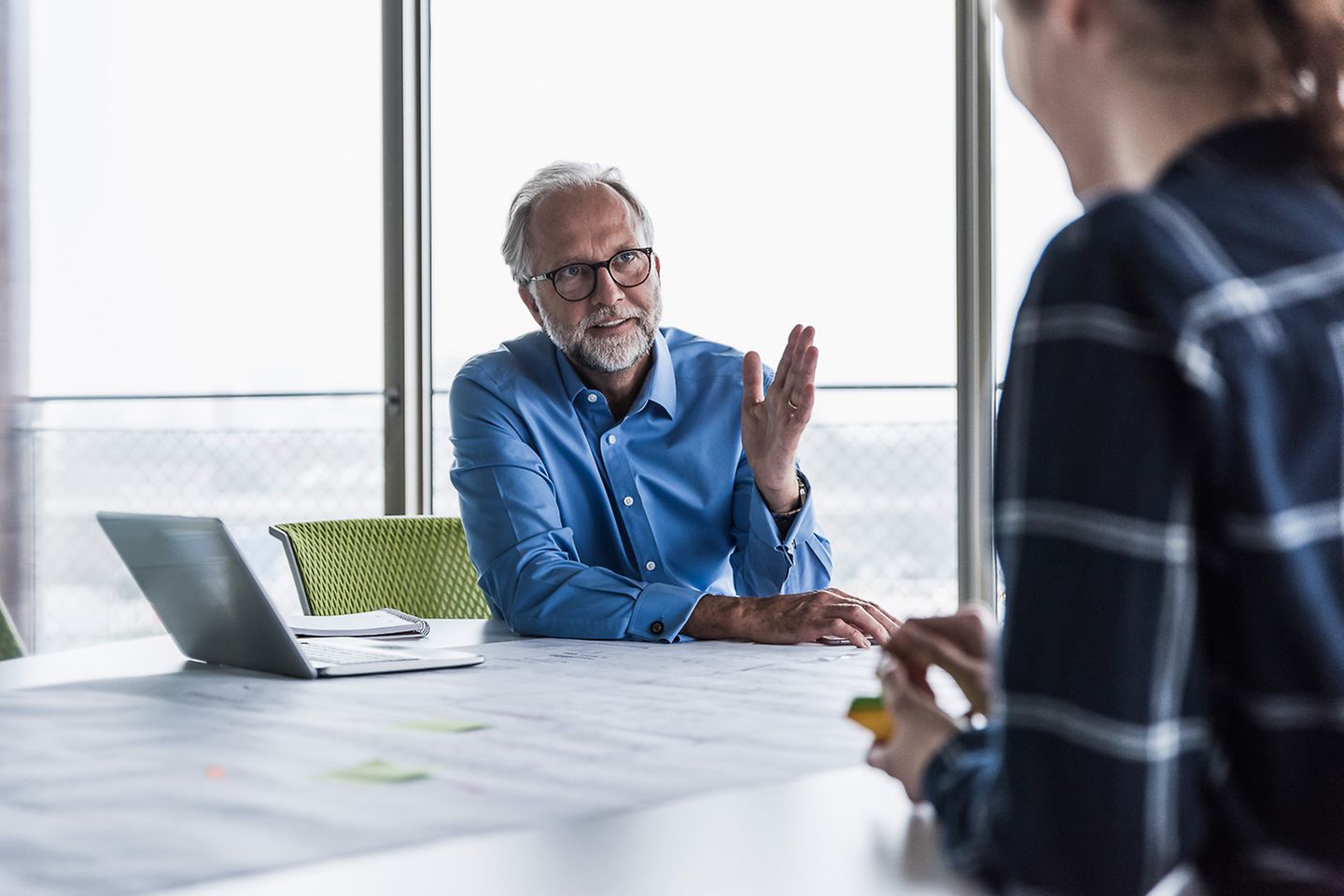 Woman and man sitting at the table in the conference room talking to each other