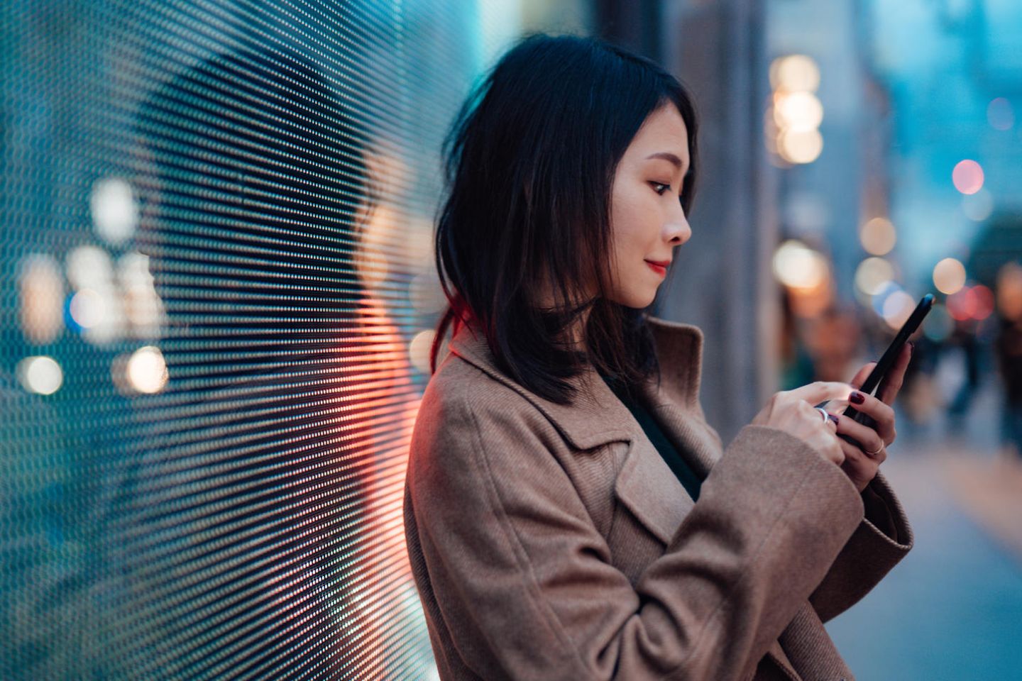 Eine junge Frau schreibt in ihr Smartphone