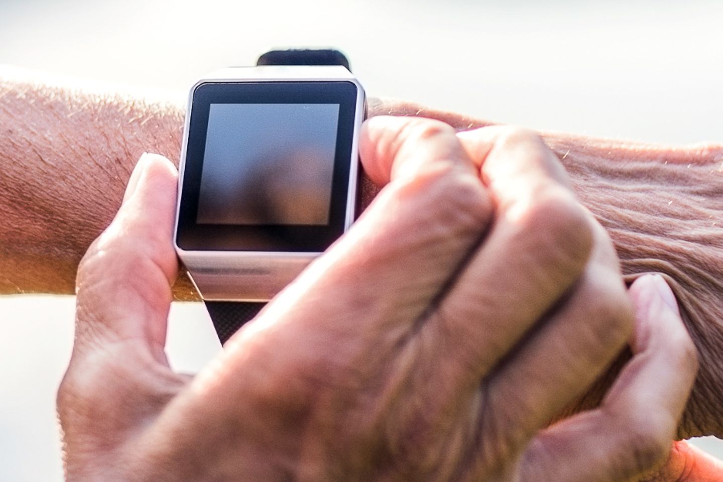 Nahaufnahme einer Uhr am Handgelenk, die von der anderen Hand gehalten wird