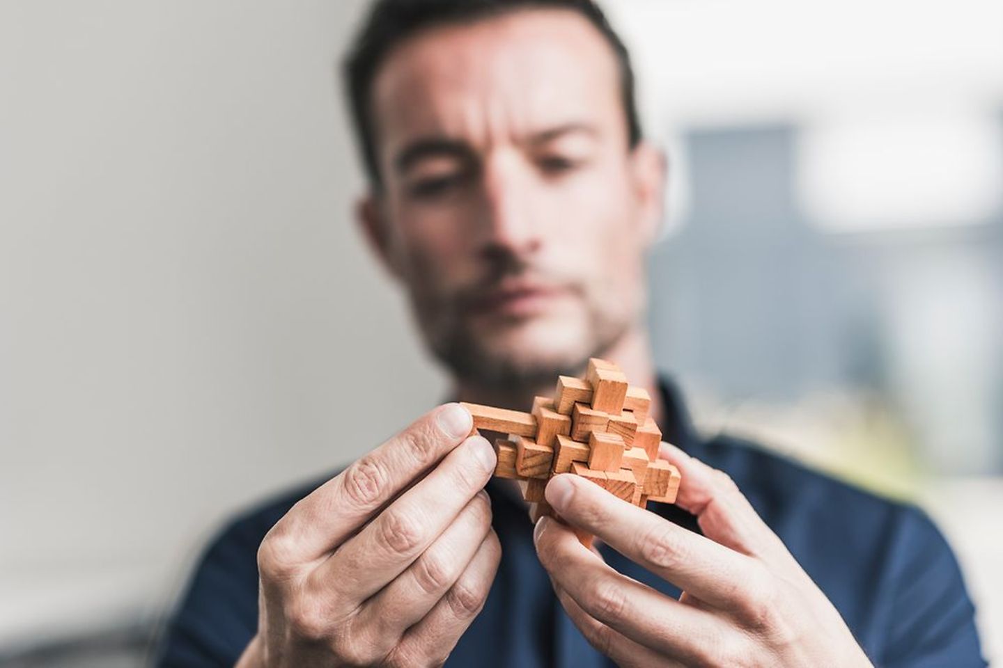  Un homme assemble un cube en bois – délicat, tout comme obtenir une IA conforme à la loi