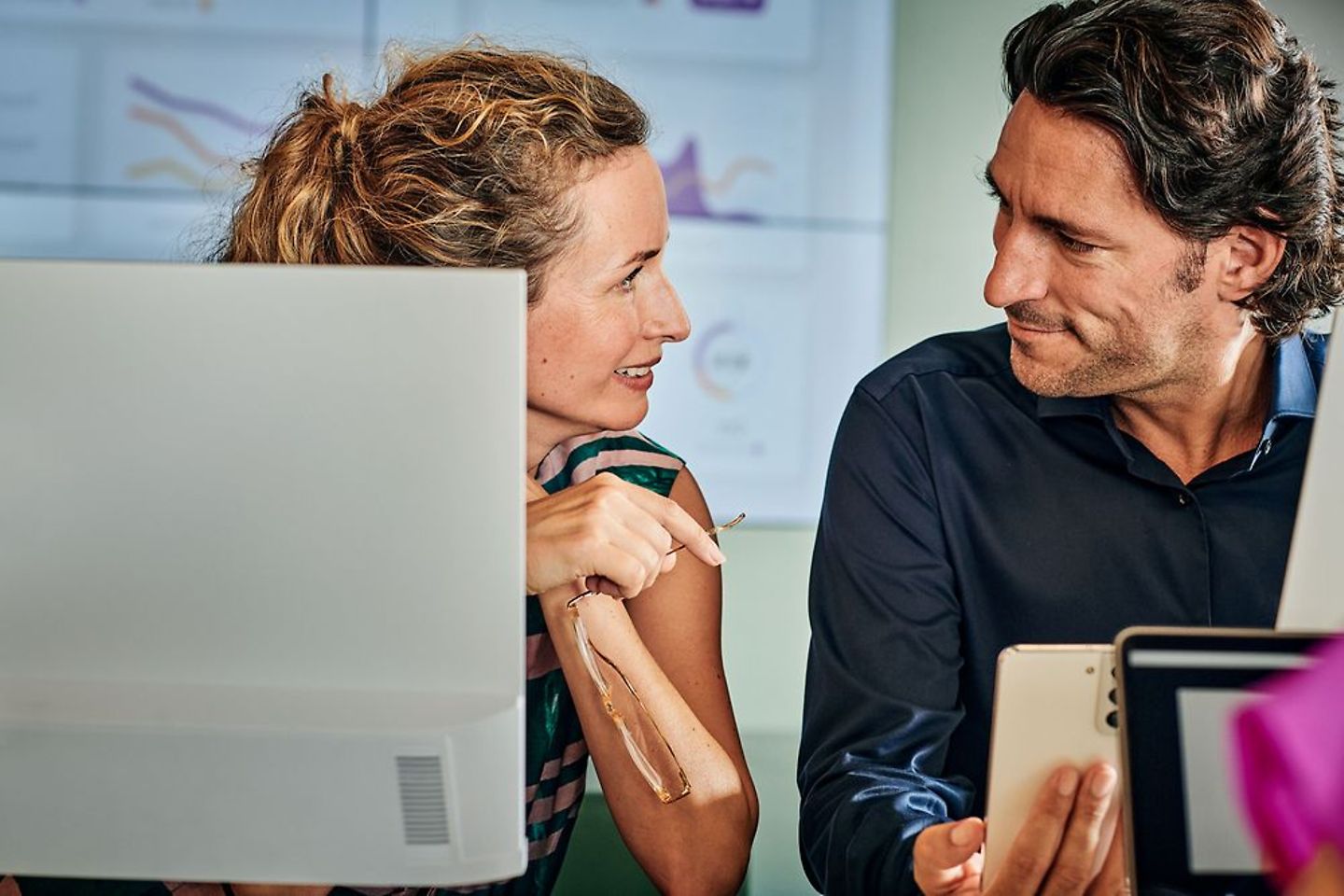 Two office workers discuss a project