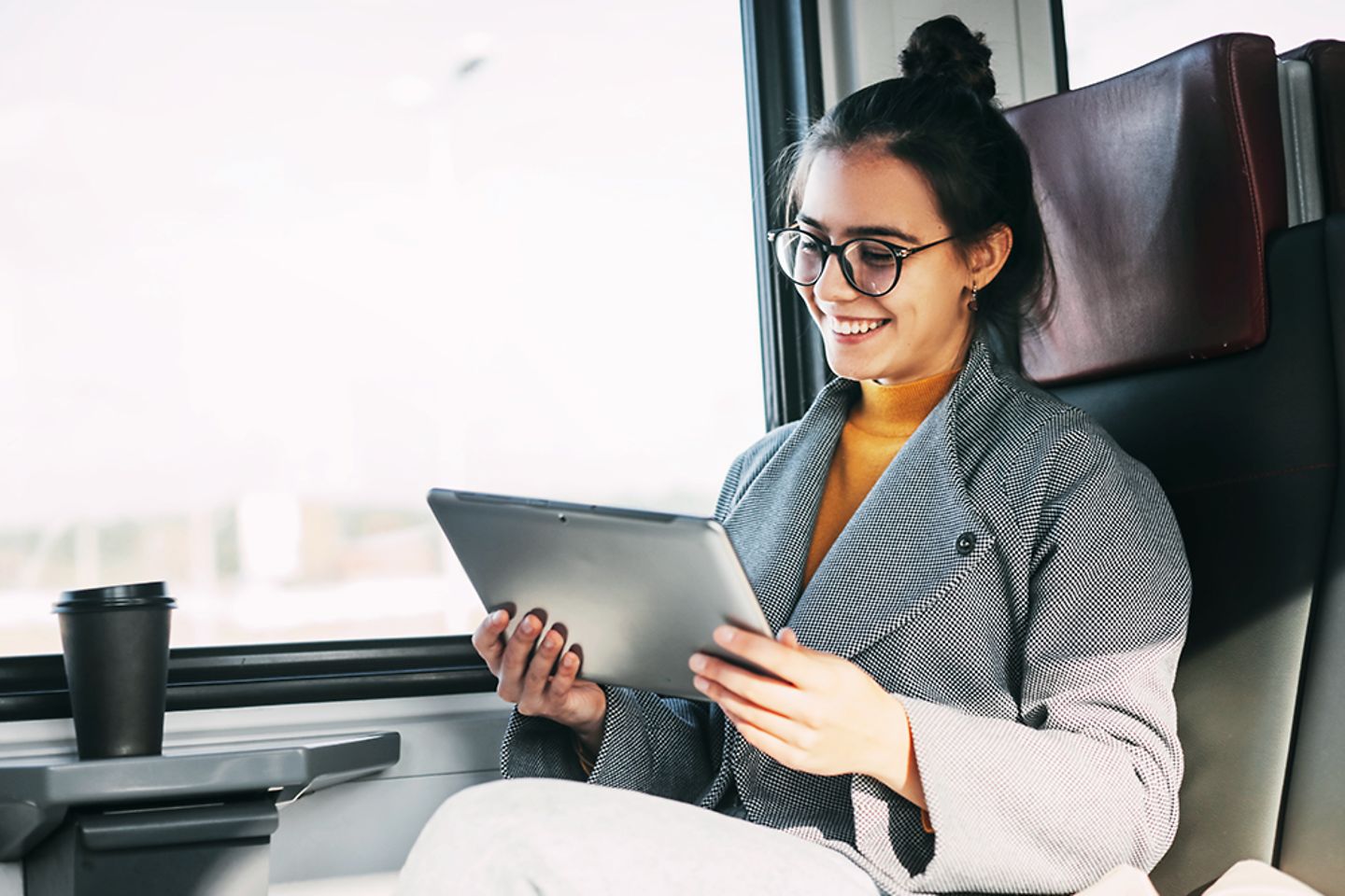 Chica en un tren usando un tablet
