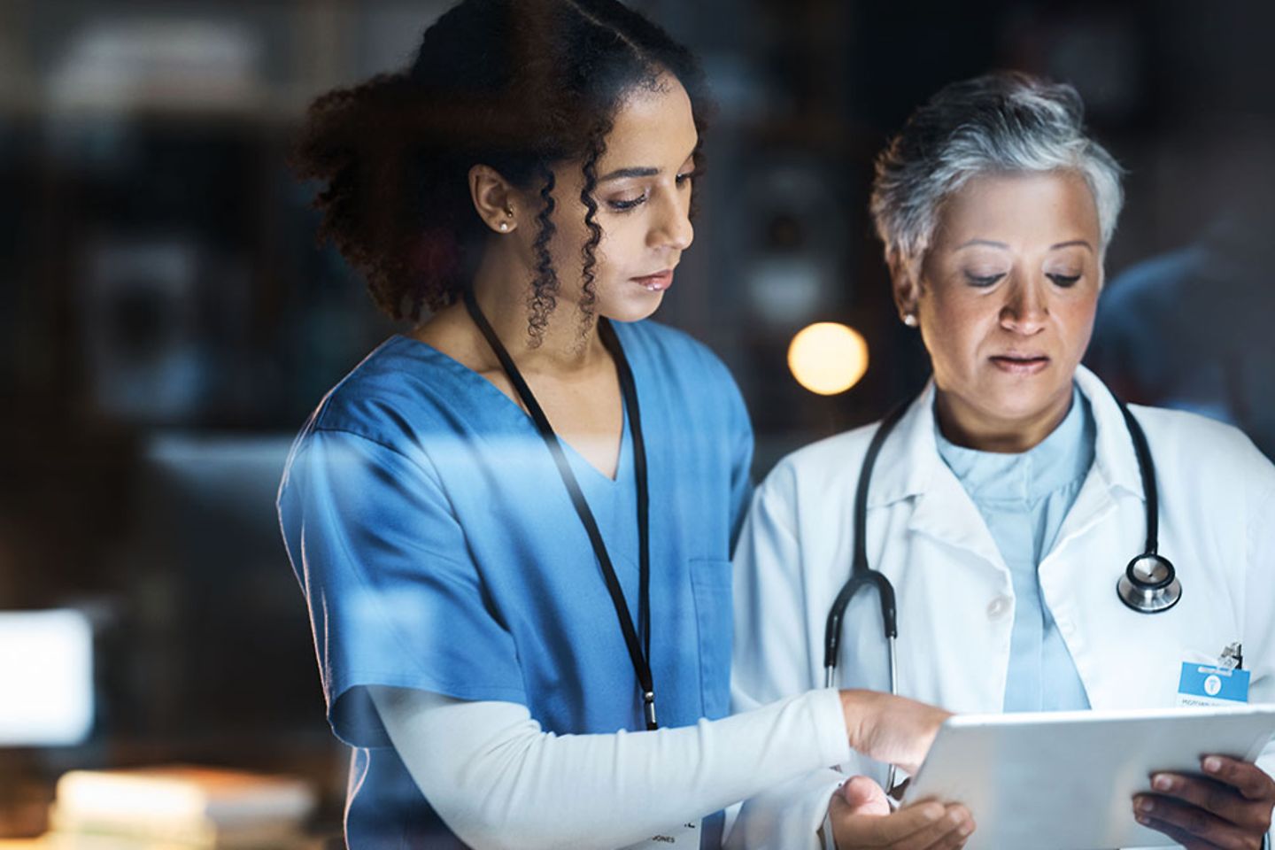Médica y enfermera analizan información en tableta