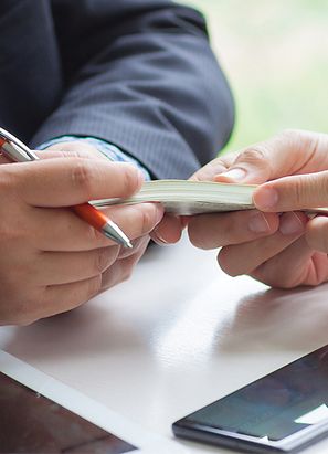 Hombre de negocios entregando dinero a otro hombre de negocios