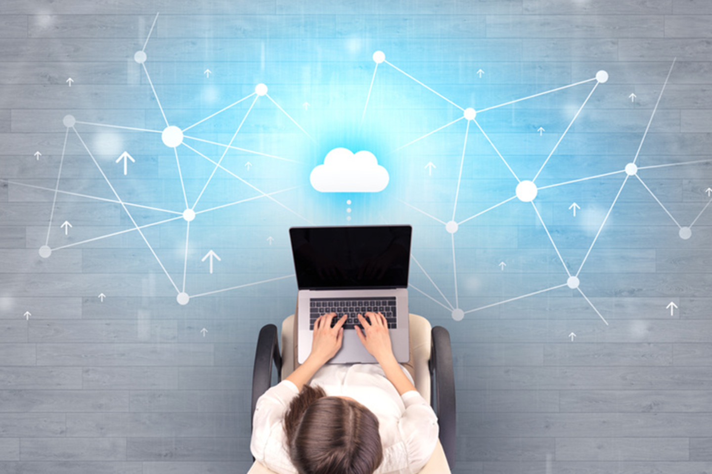 person sitzt mit Laptop unter einem Cloudnetz