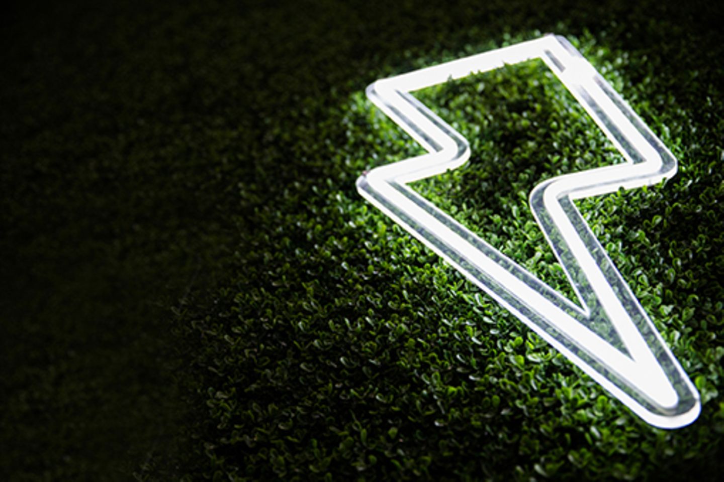 White, flash-shaped fluorescent tube on a green-black background.