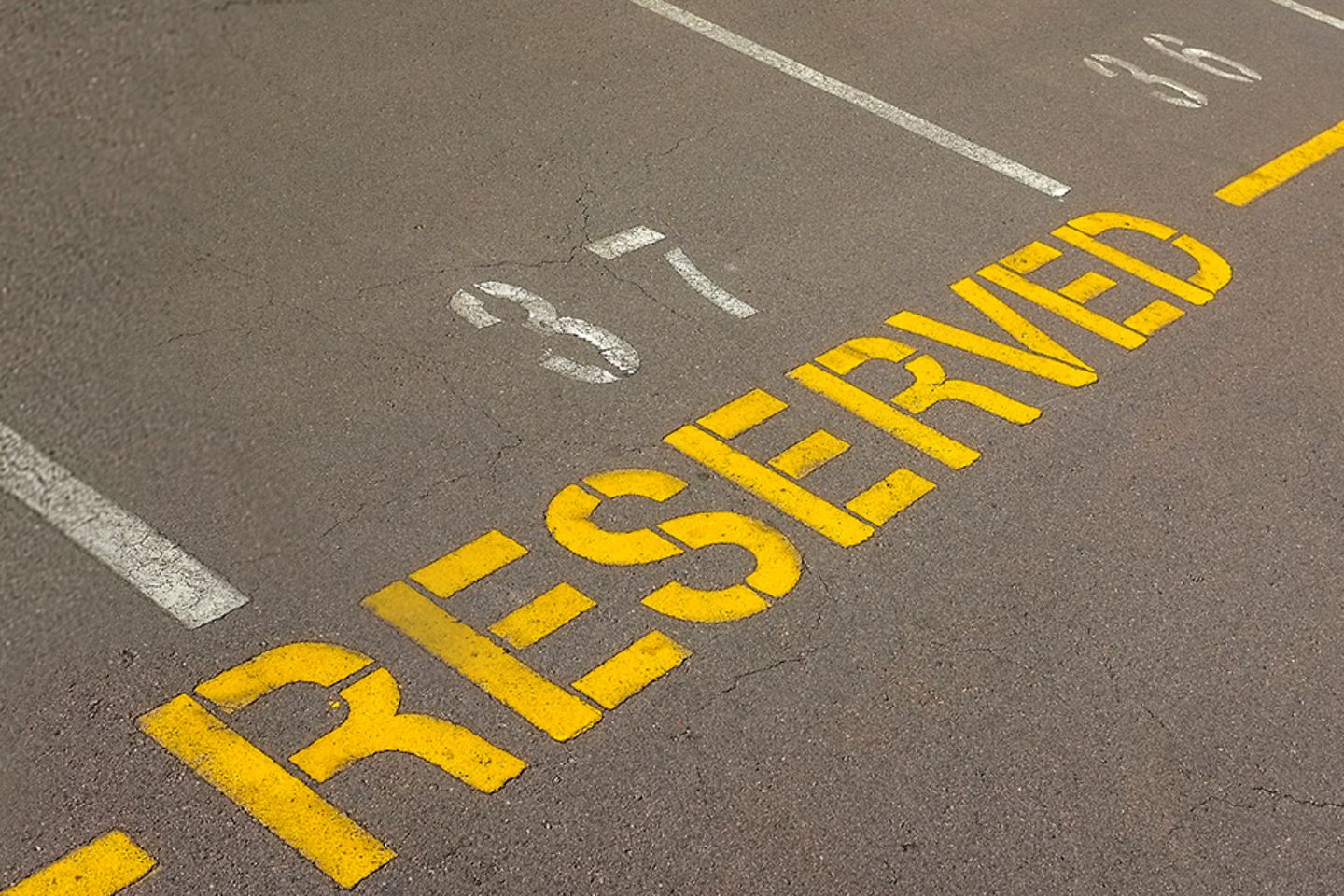 Photo of empty parking spaces, one with the inscription "reserved".