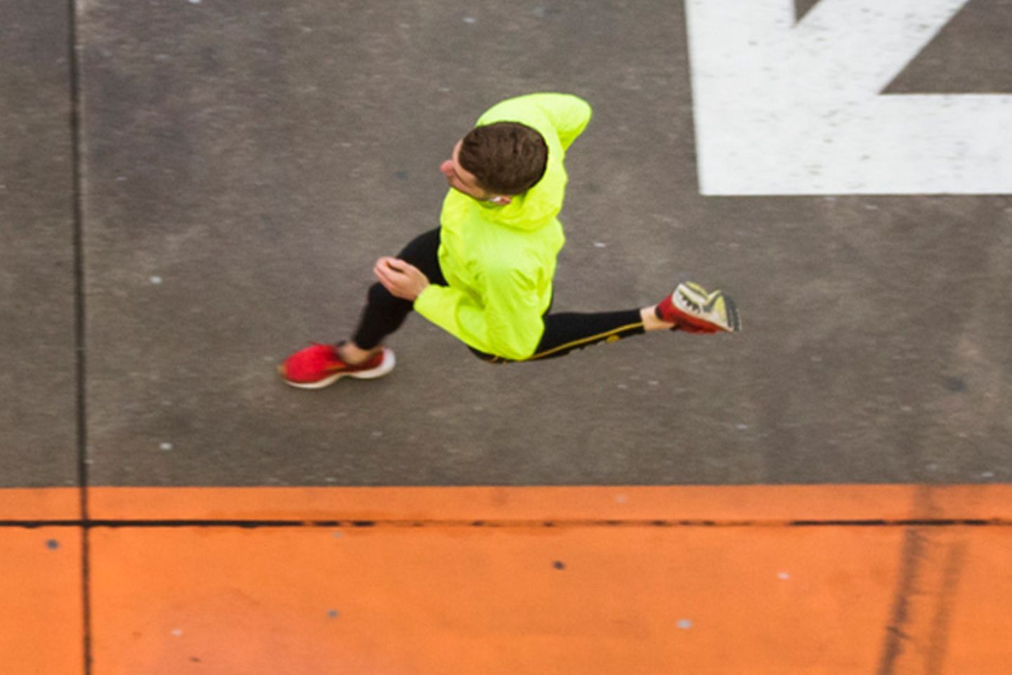 Bird's eye view of runners on road with different coloured arrows and markings.