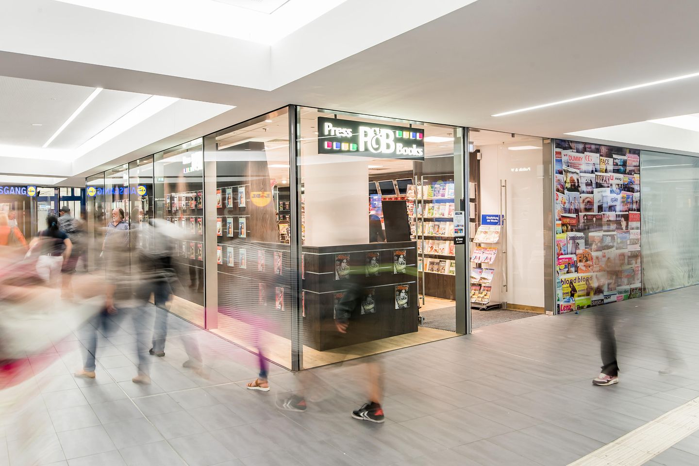 Blurred people in front of a press and book store