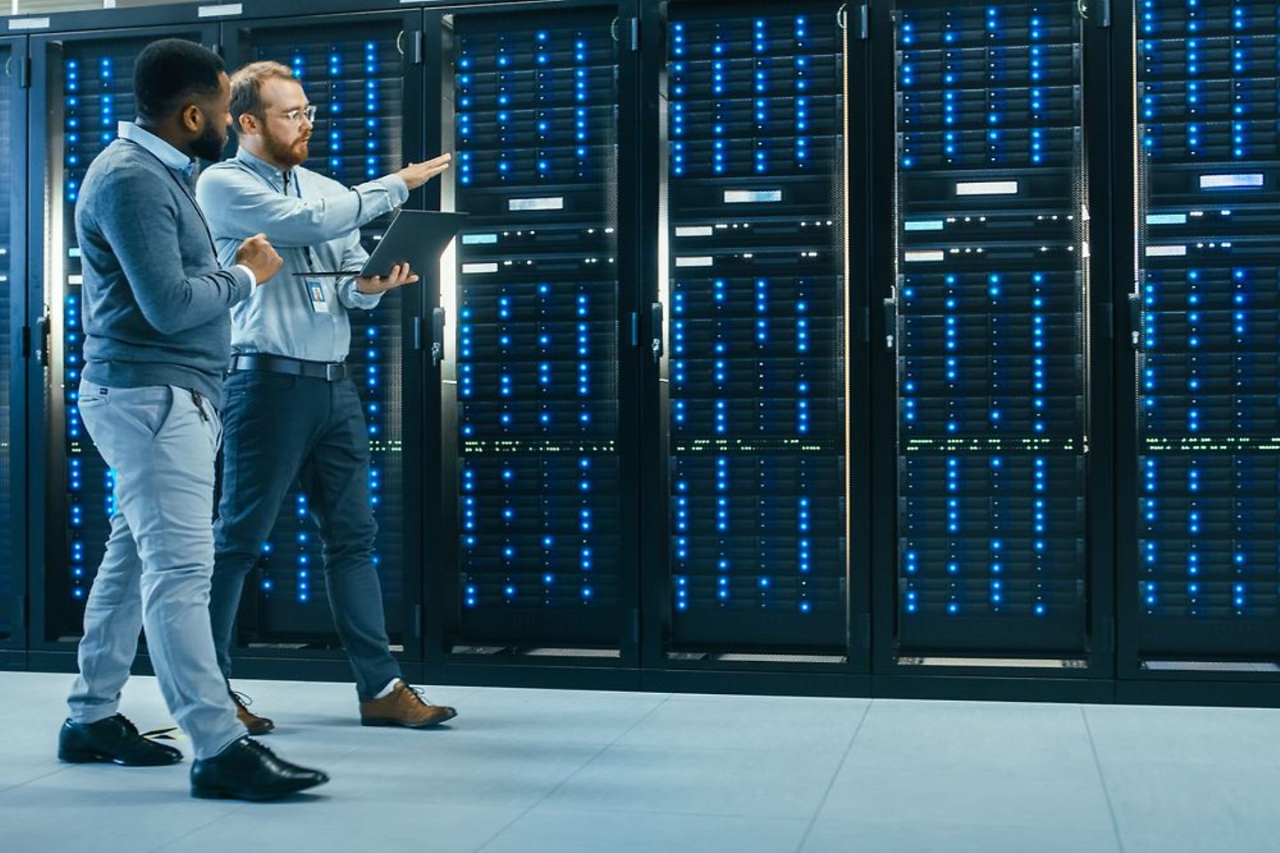 Instructor explaining information to the apprentice in a server room.