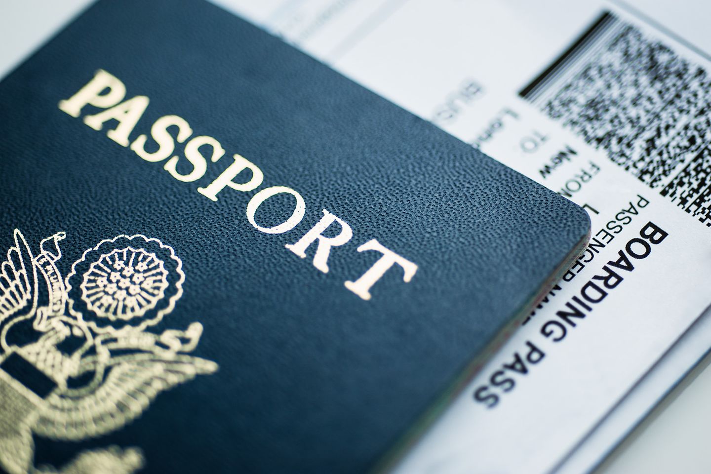 Un passeport est posé sur une carte d’embarquement.