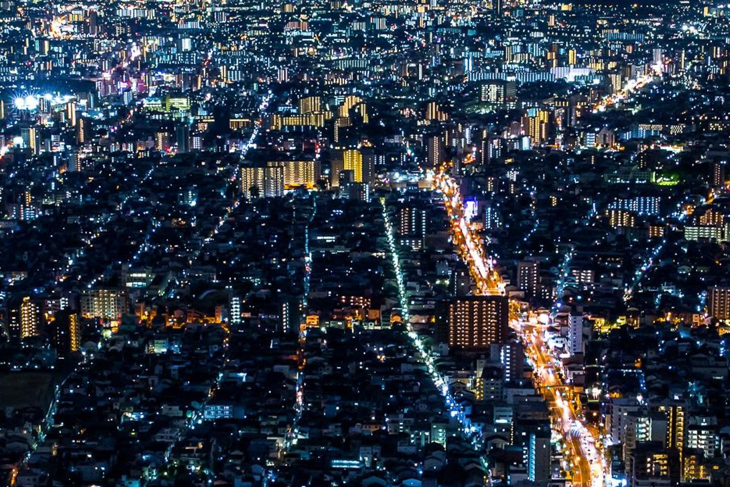 Perspective aérienne d’une grande ville de nuit, avec de nombreuses lumières