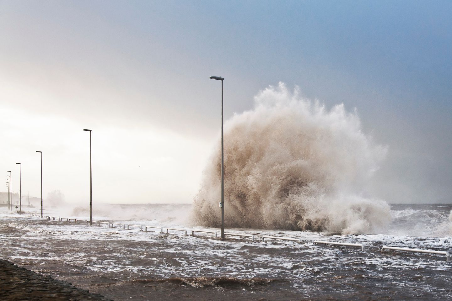 Une inondation submerge une rue longée de lampadaires