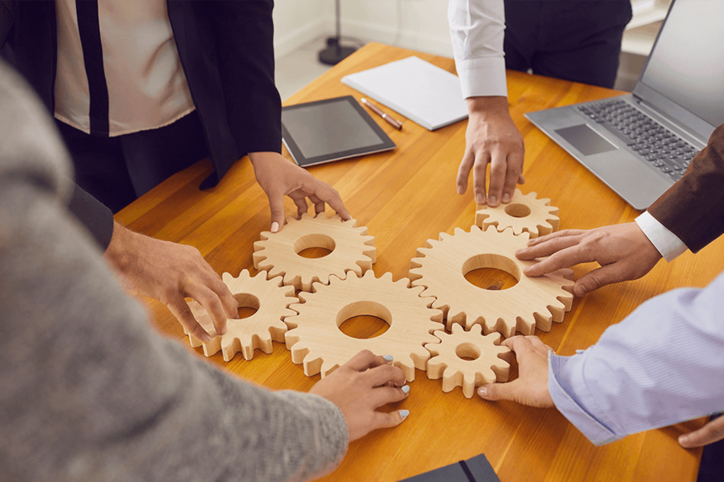 Company workers joining cogwheels as metaphor for teamwork, business system and working solutions