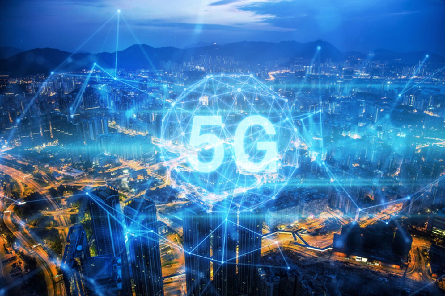 A big city at night, in the foreground a bright blue network with the lettering 5G.